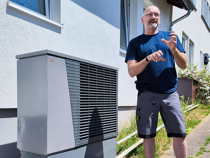 Wärmepumpe von Roth, daneben erklärt ein Facharbeiter die Funktion